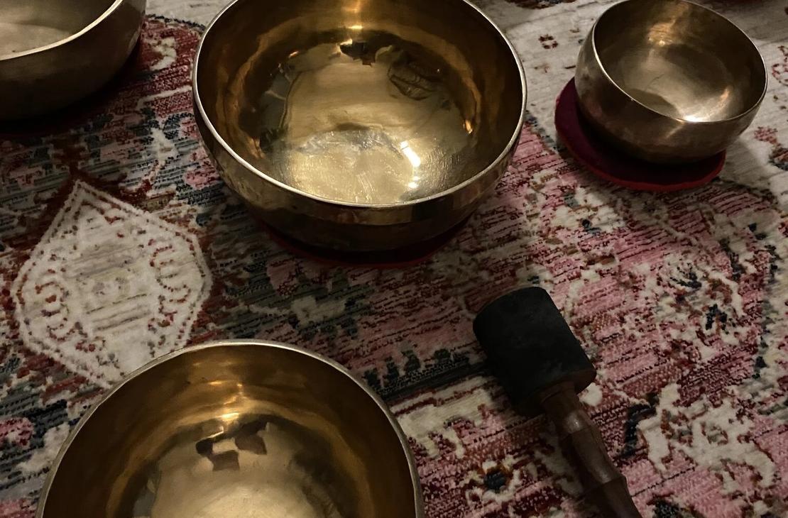 Tiibetilaisiä metallikulhoja matolla.
