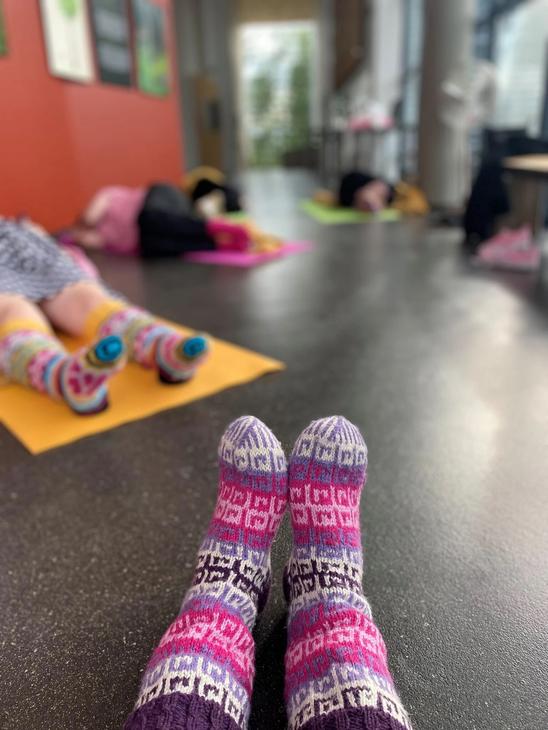 Osallistujat villasukkarentoutuksen värikkäissä paksuissa villasukissa.