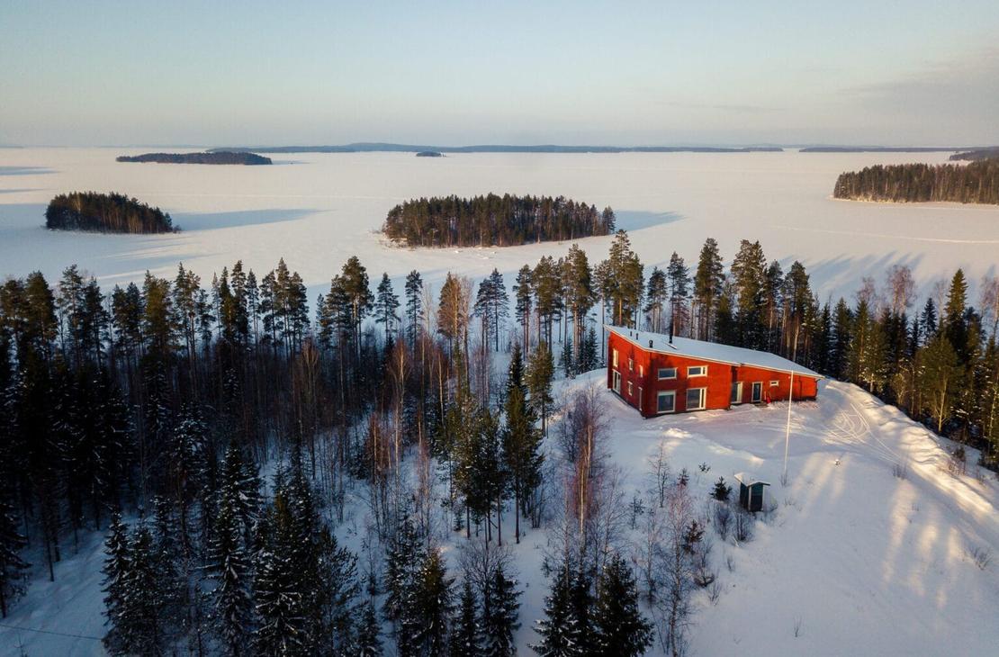 Vaarinkallion punainen huvila pienen m&auml;en laella Pielisen rannassa.