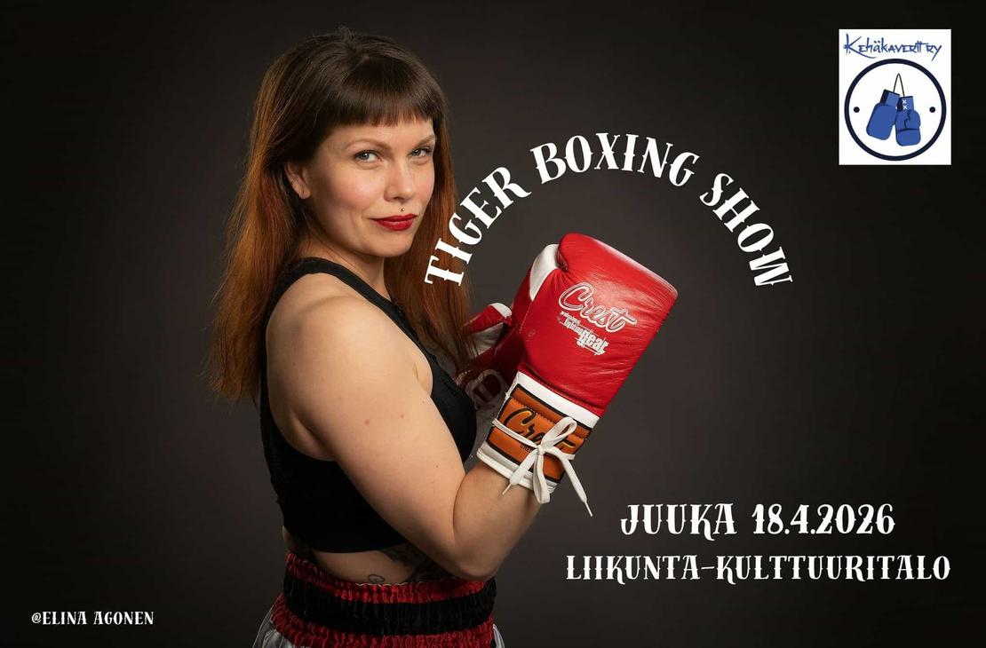 Naisnyrkkeilijä poseeraa punaiset hanskat pystyssä.