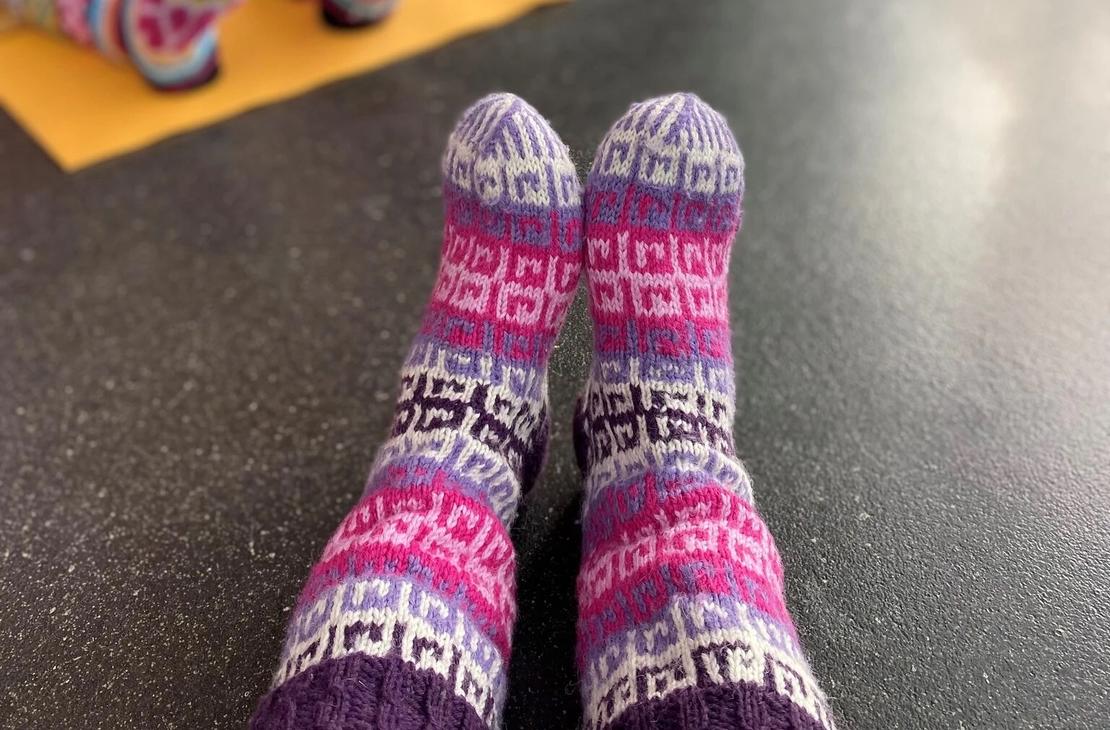 Osallistujat villasukkarentoutuksen värikkäissä paksuissa villasukissa.